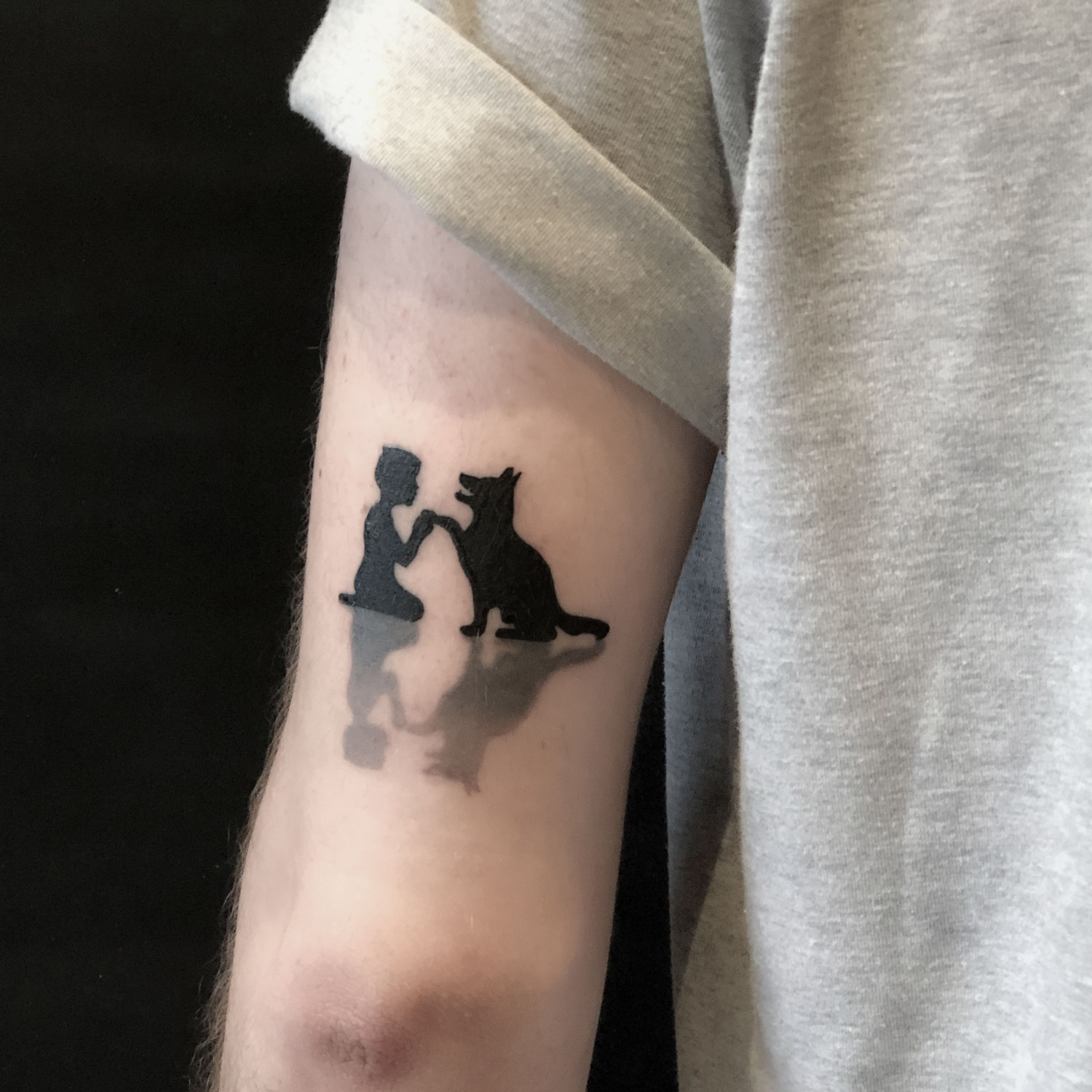 tatuaje blanco y negro perro y niño
