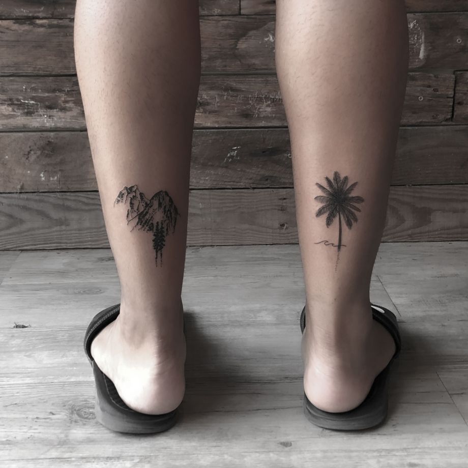 Tatuajes black work de una palmera y una montaña