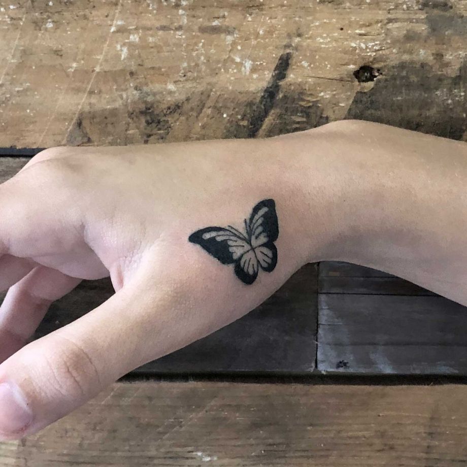 Tatuaje black work de una mariposa en la mano