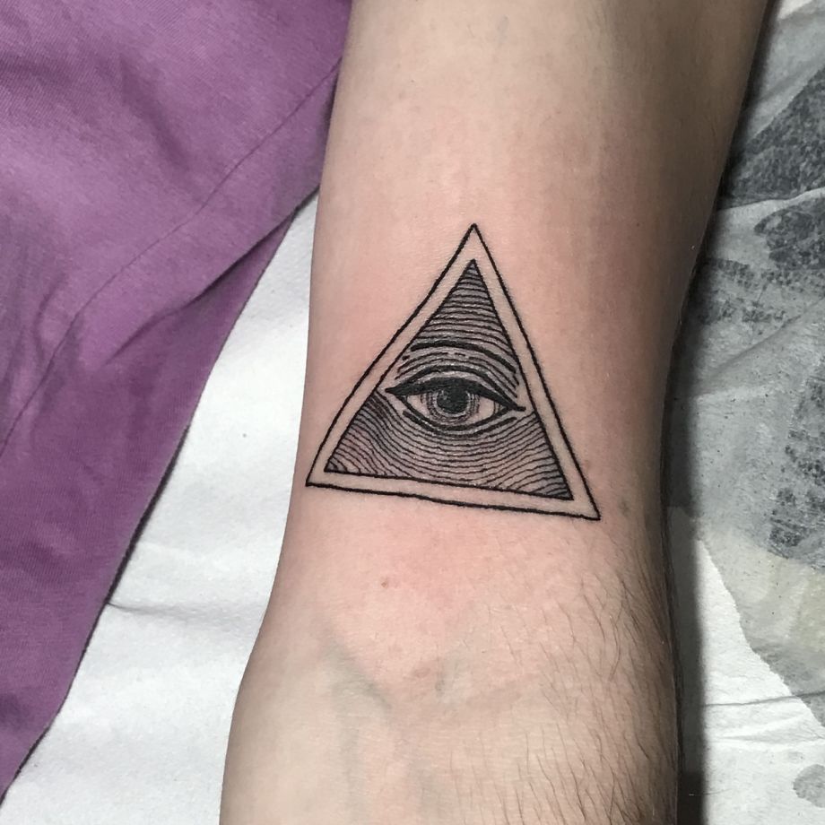 Tatuaje black work de un ojo dentro de un triángulo
