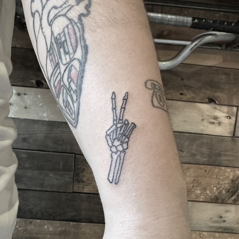 Tatuaje fine line de una mano de un esqueleto