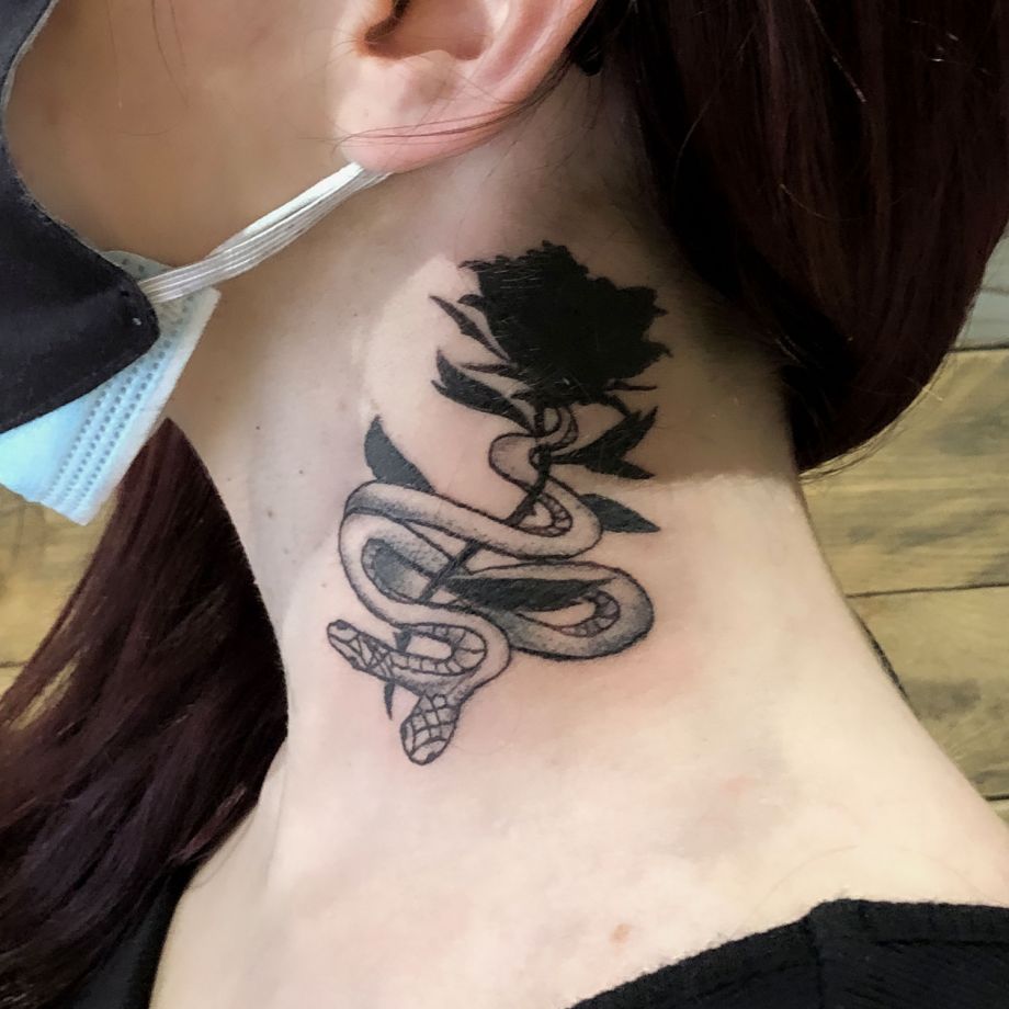 Tatuaje black work de una serpiente y una rosa