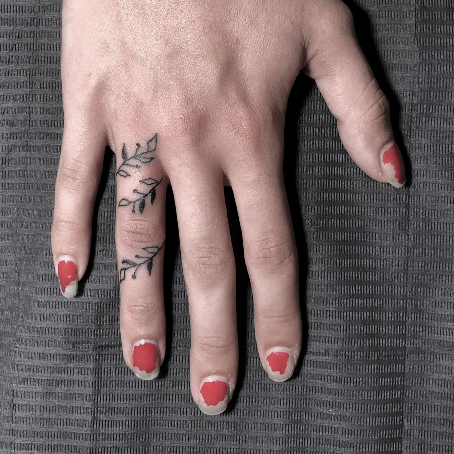 Tatuaje fine line de unas hojas en el dedo