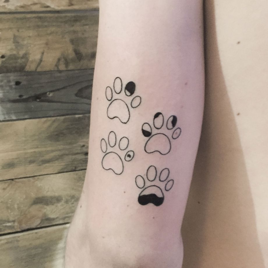 Tatuaje fine line de las huellas de un perrillo